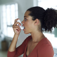 A girl using an asthma inhaler.