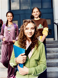 Three girls standing infront of a building.