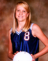 Blonde girl in a basketball jersey holding a basketball.