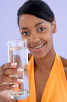 Woman holding a glass of water.