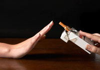 A hand pushing away a box of cigarettes.