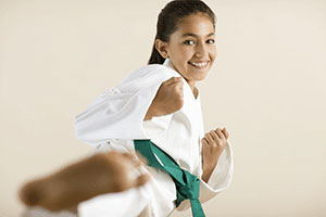 A girl doing a karate kick.