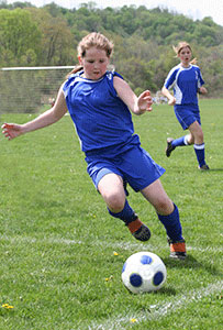 A girl playing soccer.