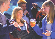 A girl being offered beer.