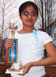 Kavya Shivashankar holding her spelling bee trophy